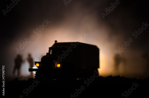 Truck in the conflict zone. The war in the countryside. War vehicle silhouette at night. Battle scene.