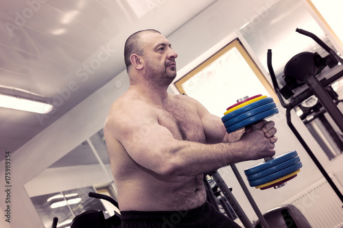 The adult brutal man is engaged in power bodybuilding in the gym © lester120