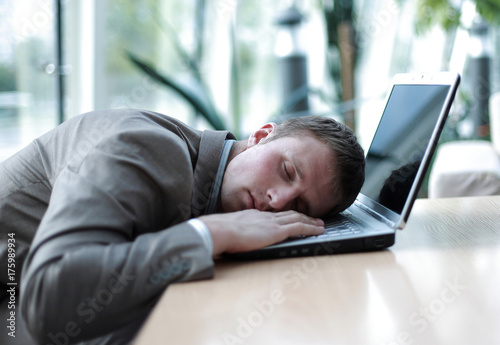 Photos A tired business man sleeping on his laptop at the office