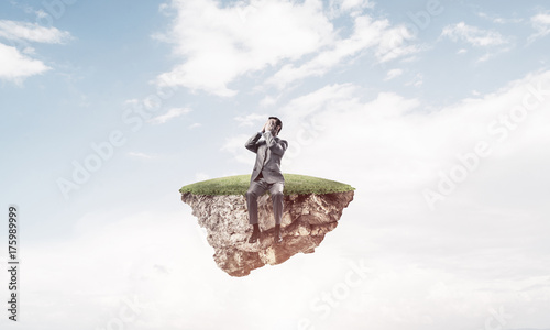 Young man on floating island in blue sky do not want to see anyt photo