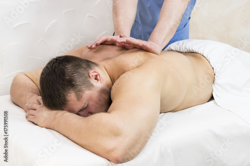 The process of sports massage is done by a man in a massage salon 