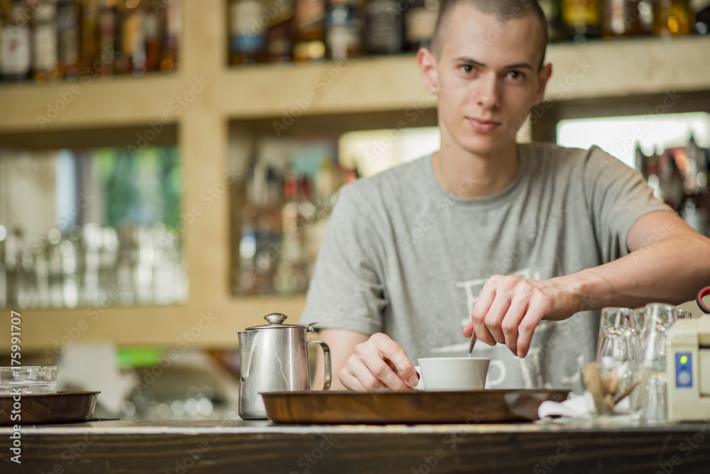 Barista bartender stirring coffee in a small espresso cup in a coffee shop Barista bartender stirring coffee in a small espresso cup in a coffee shop