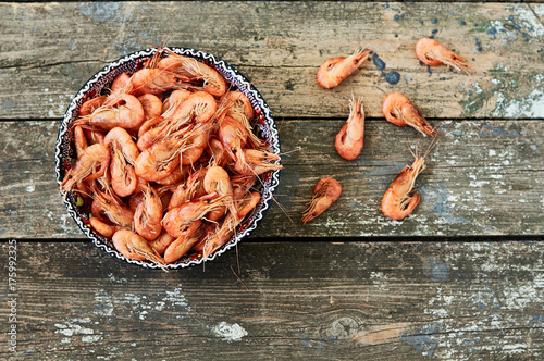 Prepared shrimp on blue plate on wooden background. Top view