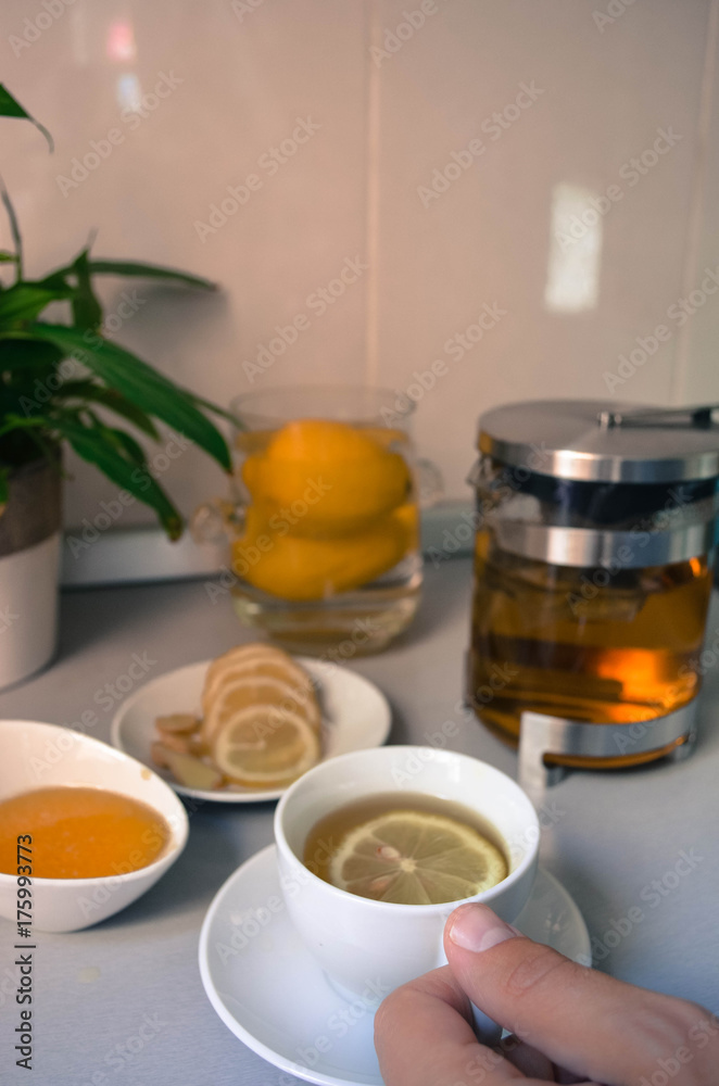 A man is holding cup of tea on the kitchen table A man is holding cup of tea on the kitchen table