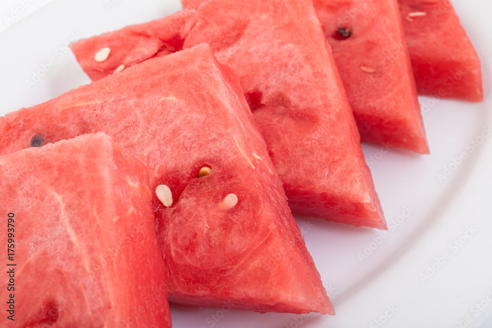 Triangle slices of fresh and juicy watermelon on white plate Triangle slices of fresh and juicy watermelon on white plate