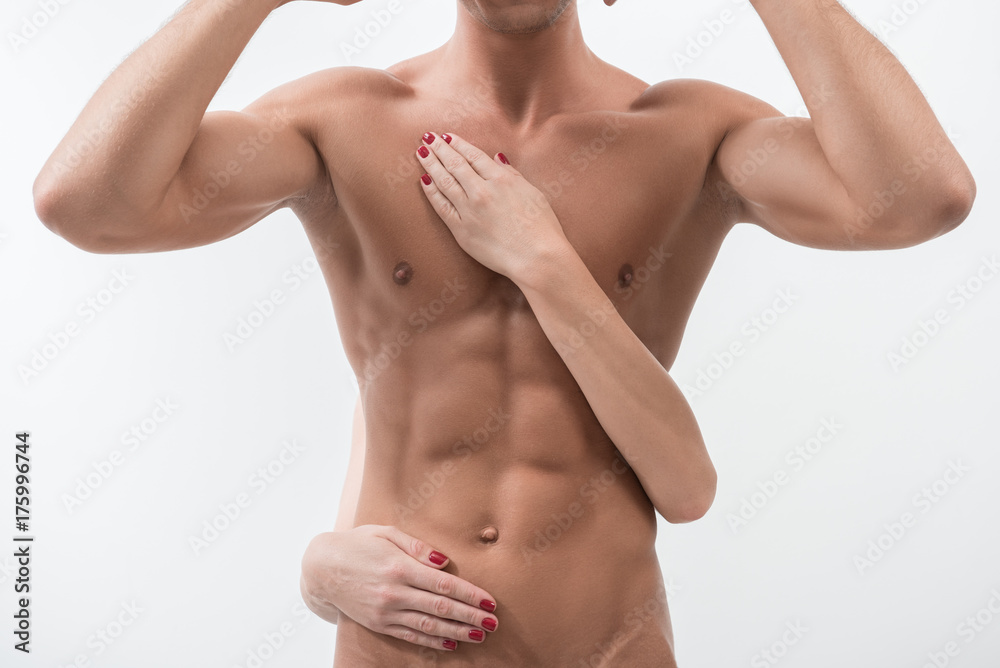 Charming guy is standing with raised arms Charming guy is standing with raised arms