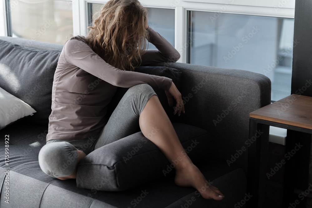 Sorrowful girl situating on couch Sorrowful girl situating on couch