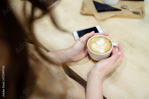 a cup of coffee with milk on a wooden tray