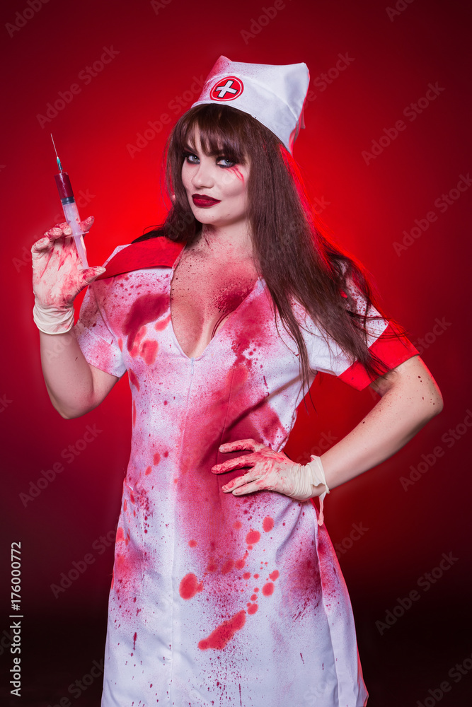 Beautiful, sexy woman, a vampire, a nurse all in the blood, a portrait, a  cutout on her chest. Kill the killer, maniac. American, dress for a costume  party Halloween. foto de Stock