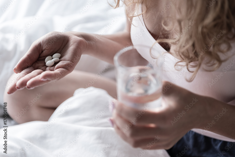 Young woman taking necessary pills Young woman taking necessary pills