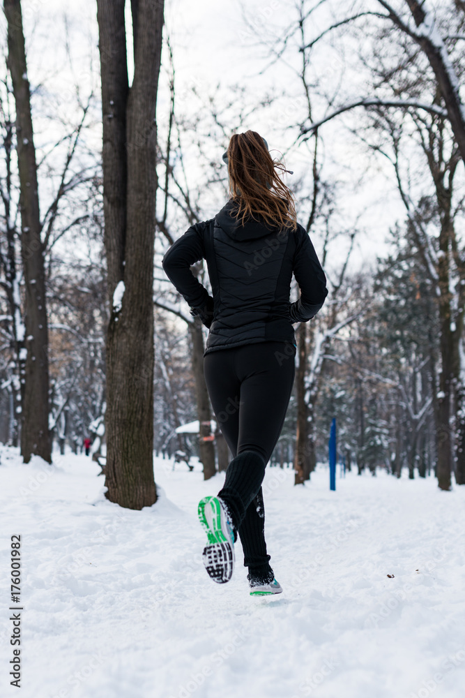 Female athlete jogging in park in winter