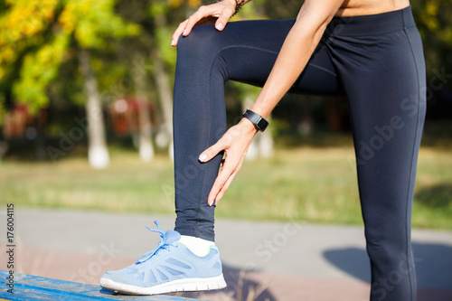 Εκτύπωση καμβά Female runner touching cramped calf at morning jogging