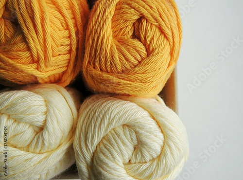 Yellow cotton yarn balls for knitting and crocheting in box.