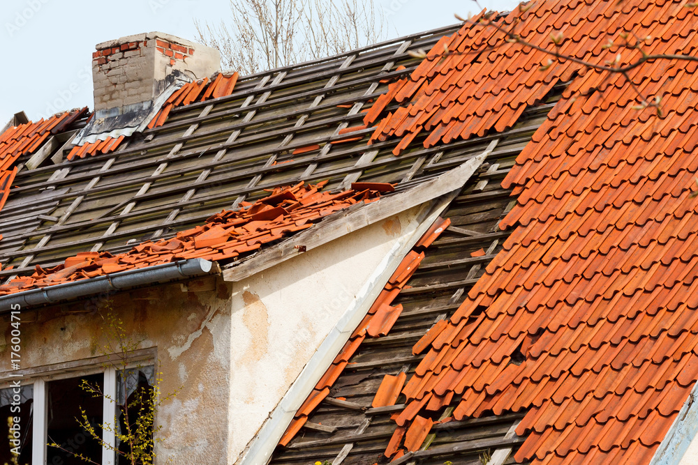 the roof of the old house with a damaged coating of red ceramic tiles the roof of the old house with a damaged coating of red ceramic tiles