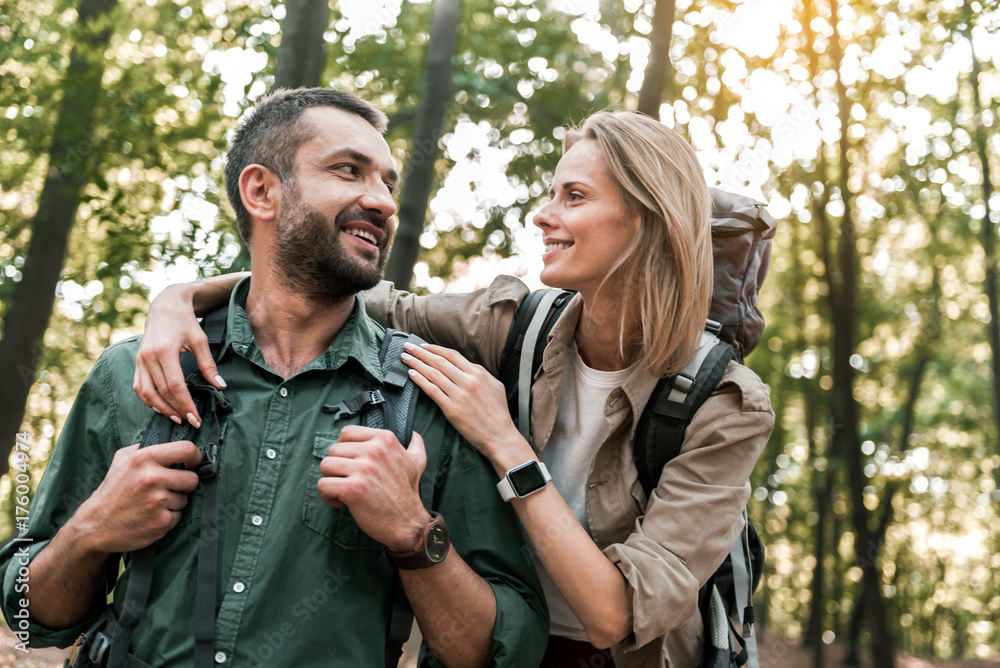 Cheerful man and woman hugging in nature