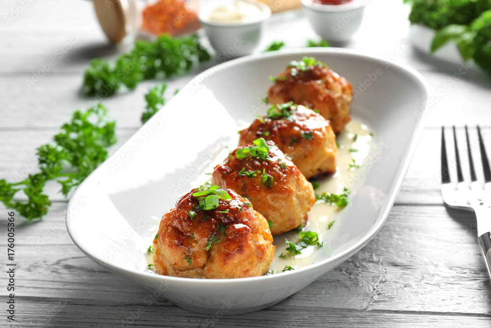Plate with delicious meatballs on wooden table Plate with delicious meatballs on wooden table