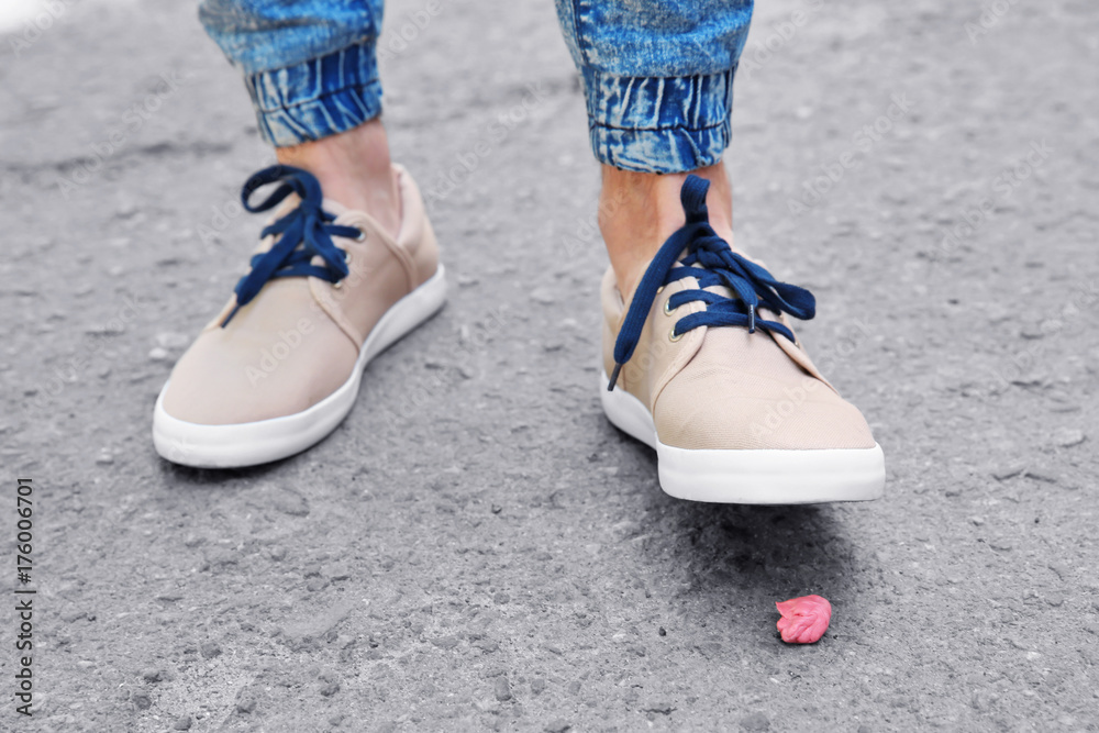 Man and chewing gum on sidewalk. Concept of stickiness