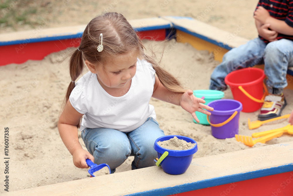 Cute little children playing in sandbox, outdoors Cute little children playing in sandbox, outdoors
