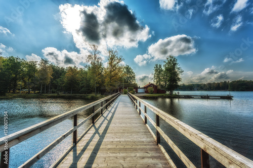 Picture of wooden bridge at the lake with blue dramatic clouds