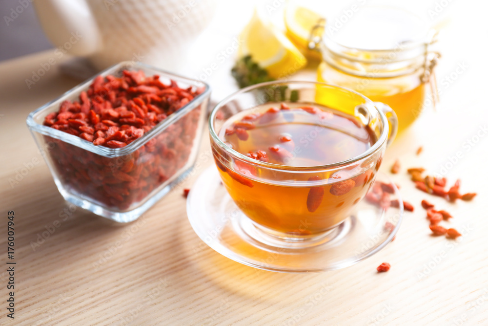 Composition with goji tea on wooden table Composition with goji tea on wooden table