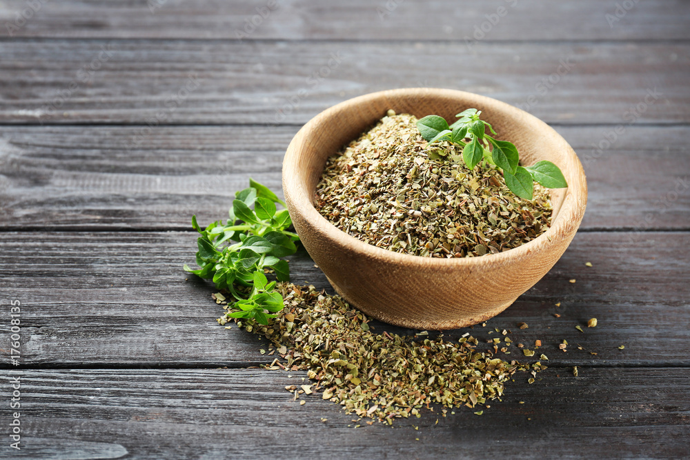 Bowl with dried oregano on wooden table Bowl with dried oregano on wooden table