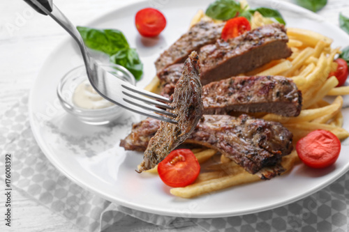 Fork with piece of delicious steak, closeup