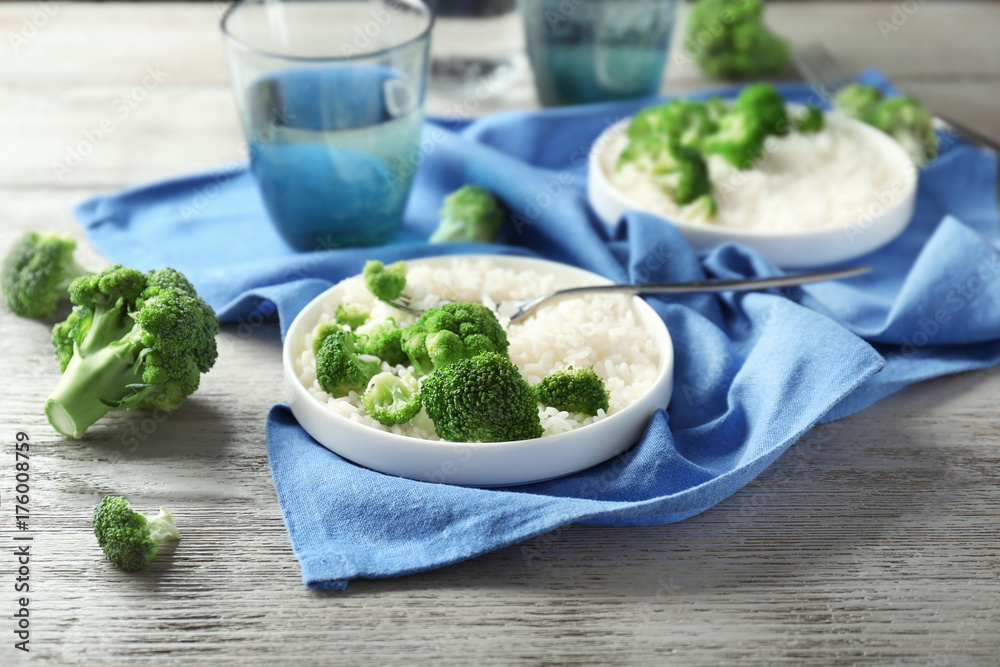 Plate with rice and broccoli on wooden table Plate with rice and broccoli on wooden table