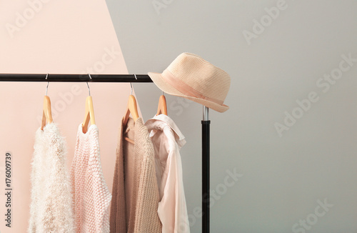Apricot and beige clothes on hangers against trendy color background photo