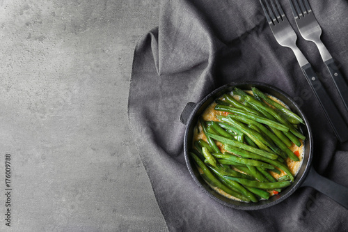 Frying pan with delicious green bean casserole on kitchen table