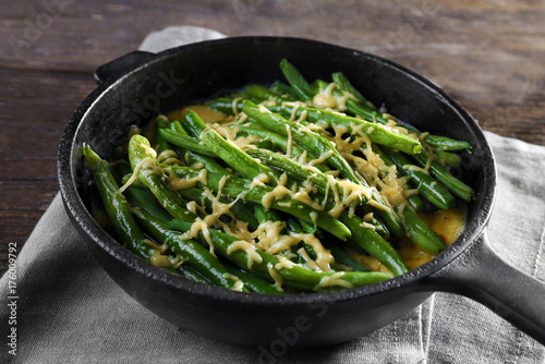 Frying pan with delicious green bean casserole on kitchen table