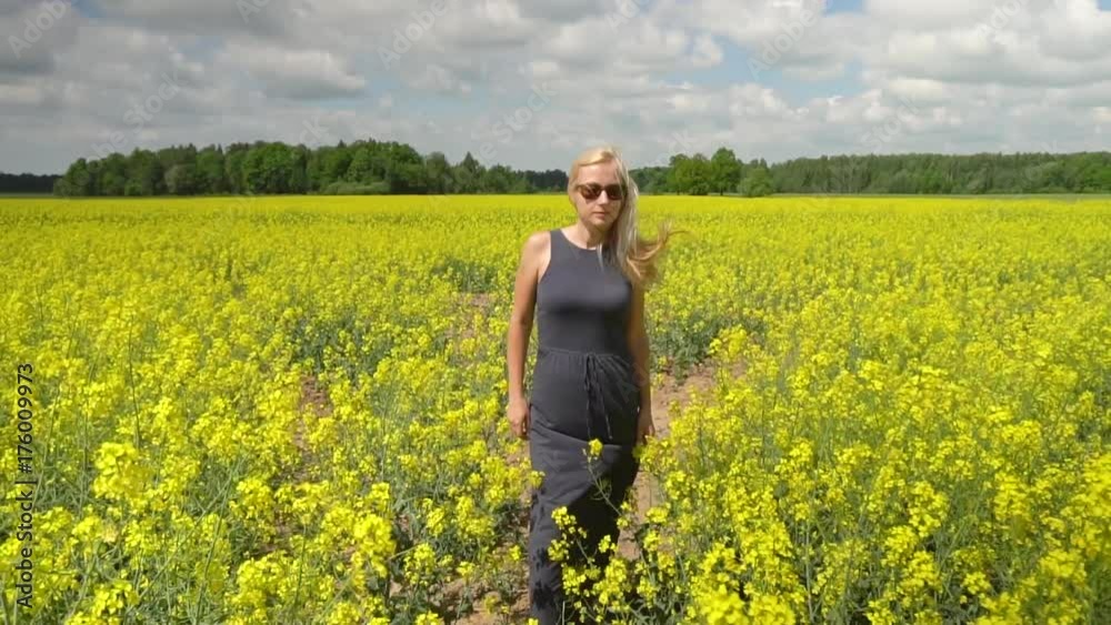 young blonde woman posing in beautiful rapeseed field young blonde woman posing in beautiful rapeseed field