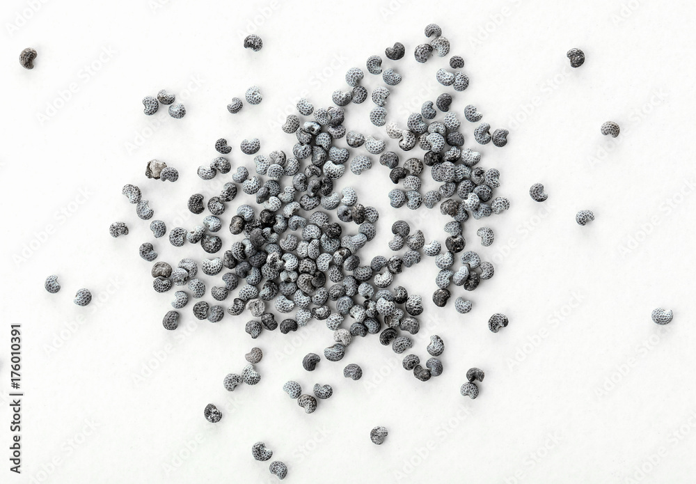 Naklejka premium Scattered poppy seeds on white background