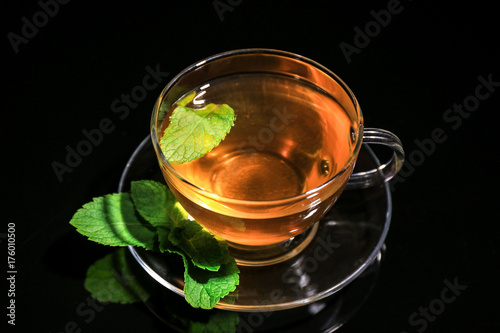 Cup of mint tea on black background