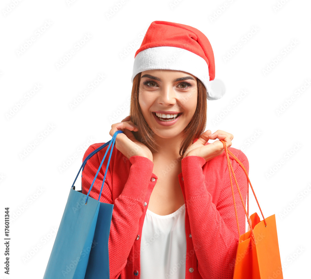 Φωτογραφία Beautiful young woman in Santa Claus hat and with bags on white background