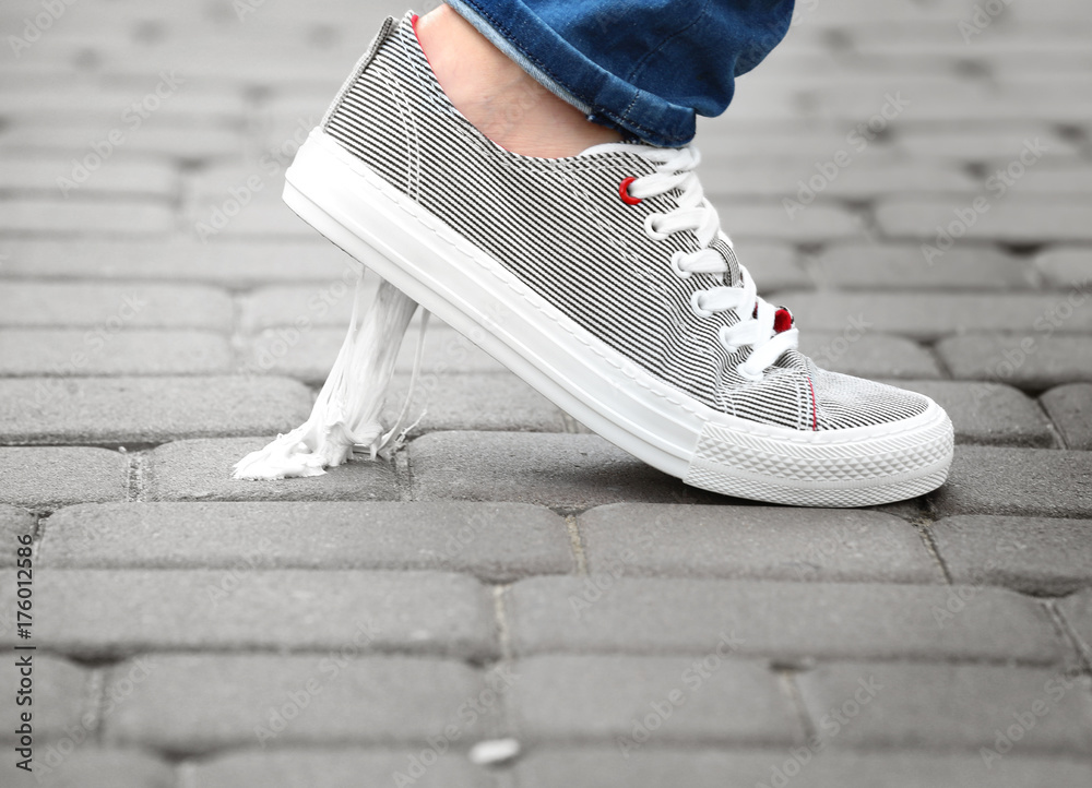 Φωτογραφία Foot stuck into chewing gum on street. Concept of stickiness