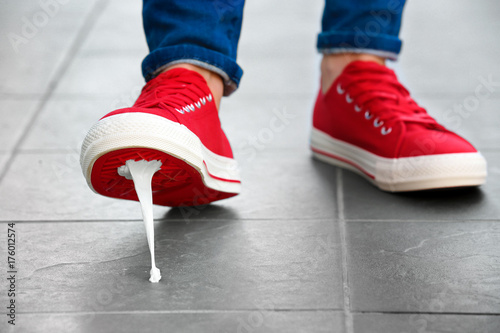 Fotografie Foot stuck into chewing gum on street. Concept of stickiness