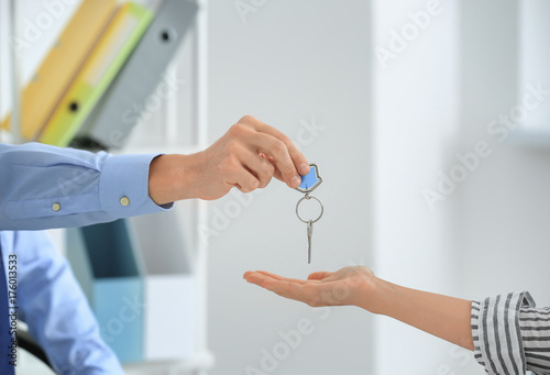 Hand of real estate broker giving customer key from new flat