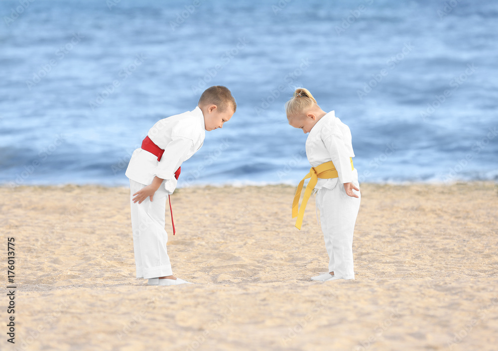 Little children performing ritual bow prior to practicing karate outdoors - obrazy, fototapety, plakaty 
