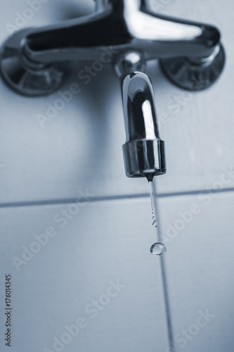 Faucet or kitchen tap leaking with water drops. Saving water concept. Close up