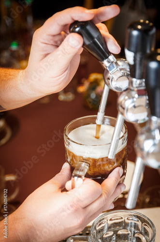 Bartender hands pouring a draught craft beer into a mug
