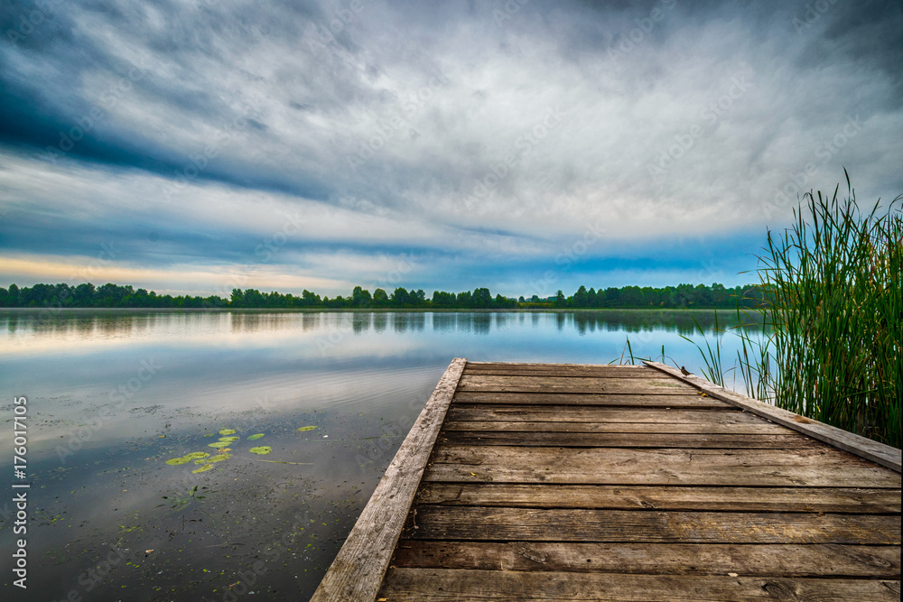 Beautifull walkway to the lake with green trees reflection, blue sky and clouds Beautifull walkway to the lake with green trees reflection, blue sky and clouds