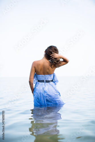 Woman in a Dress Walking in Shallow Ocean Water photo