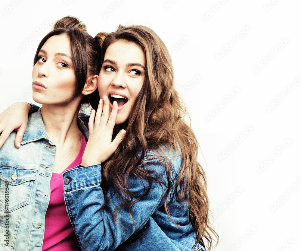 Two young beautiful smiling brunette hipster girls in trendy similar  checkered shirt and jeans clothes.Sexy carefree women posing near pink wall  in studio.Positive model sitting on her friend back Stock Photo |
