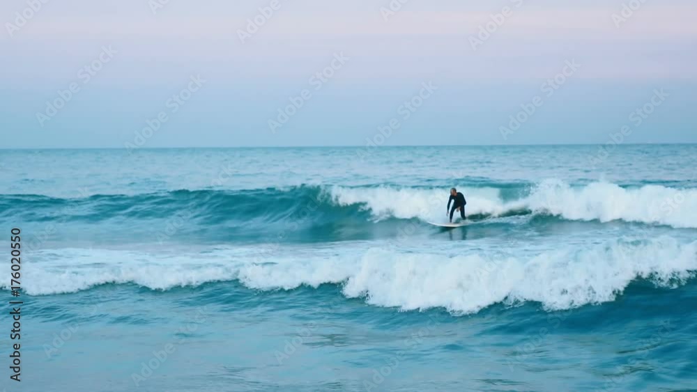 Surfer man big beautiful wave surfing surfboard surf board sea seaside resort beach evening summer alone splash breakwater ocean luxury active sports lifestyle strong body black suit shore coast pier