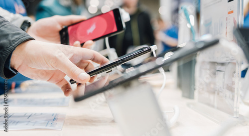 a new smartphone on the stand of the exhibition close-up. New models of gadgets at the exhibition of technologies. People choose new gadgets and smartphones