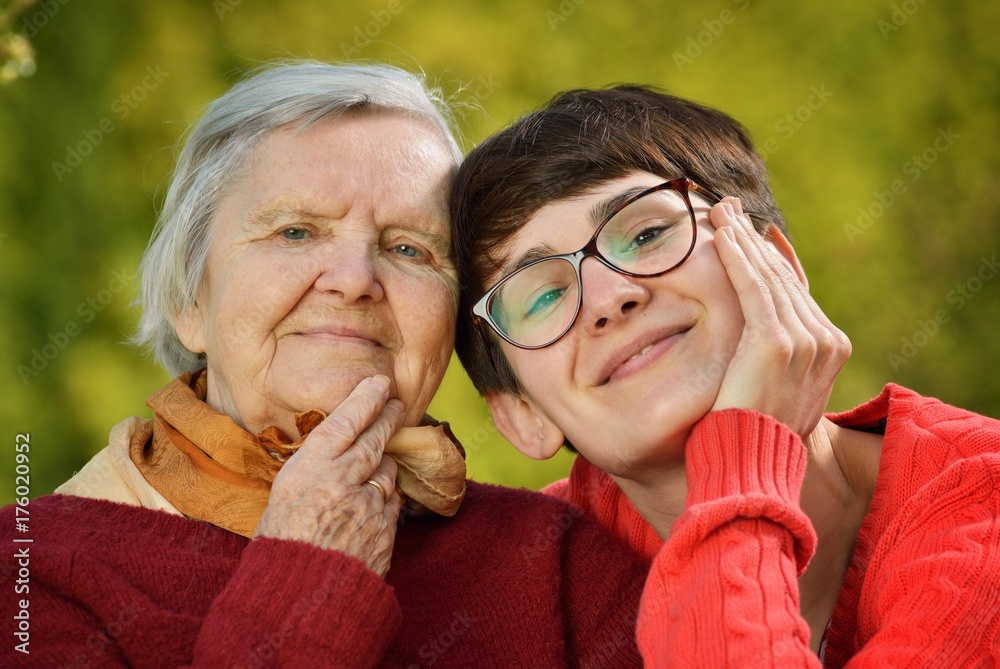 Grandmother and granddaughter. Young woman carefully takes care of an older woman.