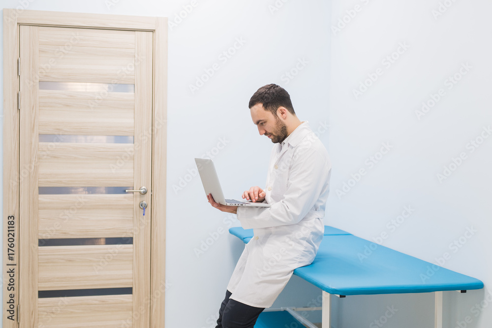 Portrait Of Doctor Holding Laptop, Indoors