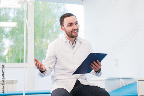 Portrait of handsome young doctor in office