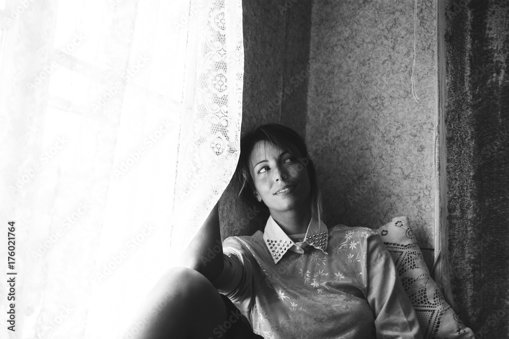 Portrait of a young woman sitting by the window Portrait of a young woman sitting by the window