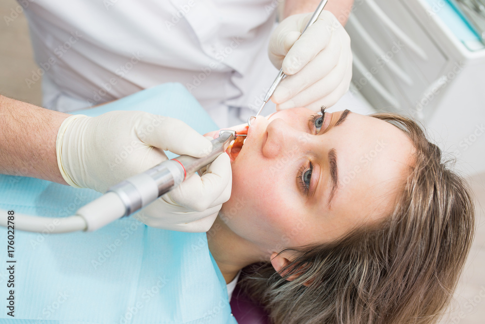 Dentist curing a female patient with drill, closeup. Dentist curing a female patient with drill, closeup.